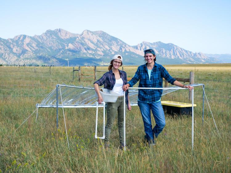 Graduate student Julie Larson and undergraduate Emily Koke in grass