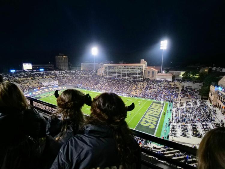 Football fans wearing Buffalo hats watch the game