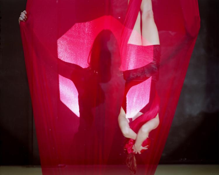 Danielle Garrison hanging a red fabric drape