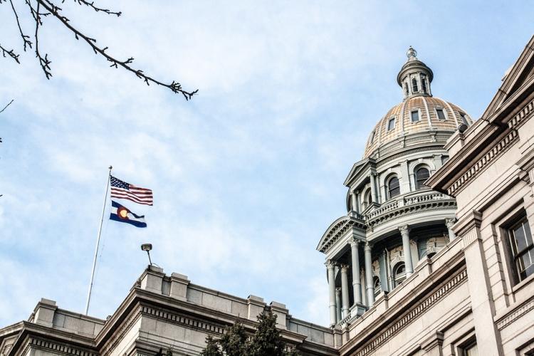 Denver capitol building with state and national flag flying