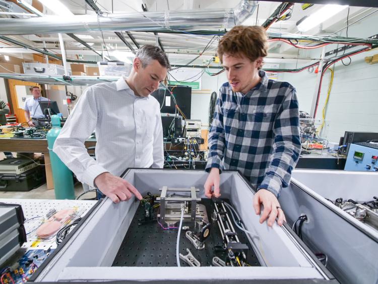 Greg Rieker (left) works with another person in a lab setting.