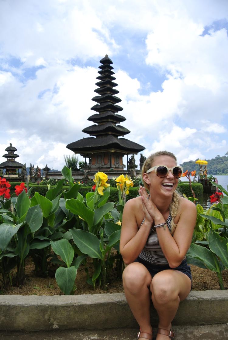 Student sits in front of temple in Indonesia