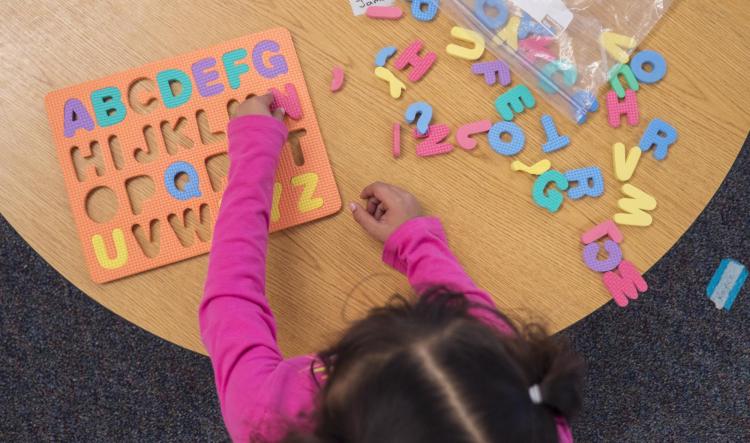Child playing with an alphabet puzzle