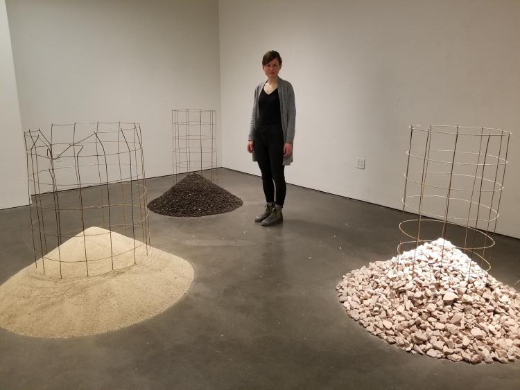 Elspeth Schulze standing among piles of sand, chopped up asphalt and granite