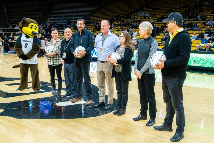 The four 2019 Chancellor’s Employee of the Year winners were honored during halftime of a recent Colorado basketball game. Left to right in this photo are: Chip the Buffalo, Jessie Kasynski, Chancellor Phillip DiStefano, J. Javier Portillo, Athletic Director Rick George, Melynda Slaughter, Ceal Barry and Alex Viggio. (Photo by Patrick Wine/University of Colorado)