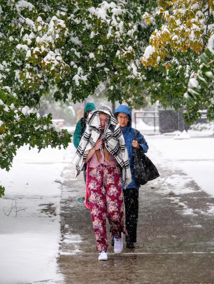 Students make their way to class during the first snowfall of the year on Oct. 10, 2019. (Photo by Patrick Campbell/University of Colorado)