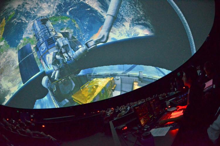 audience watching a full-dome space film at Fiske Planetarium