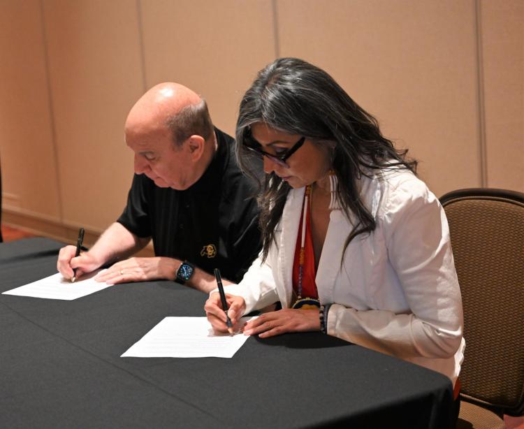 Chancellor DiStefano signing an agreement with the Southern Ute Tribe