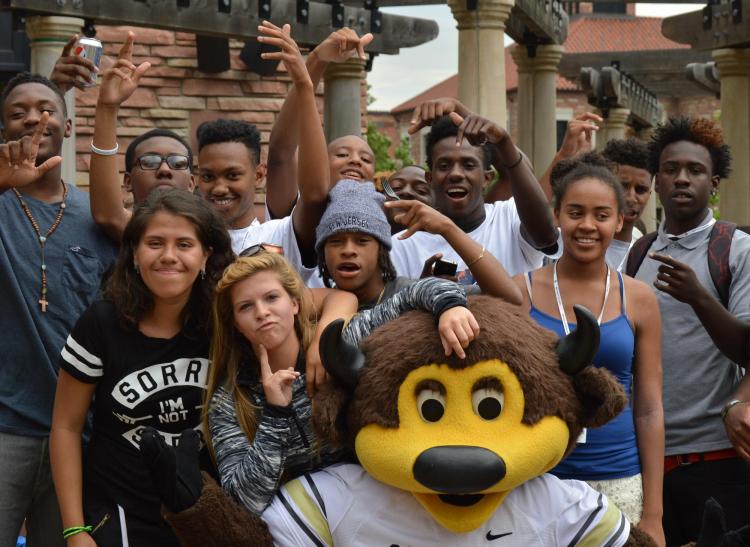A group of students poses with Chip during the boys2MEN Leadership Summit