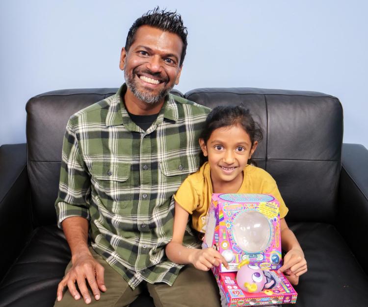 Harsha Ganga with his daughter holding a toy