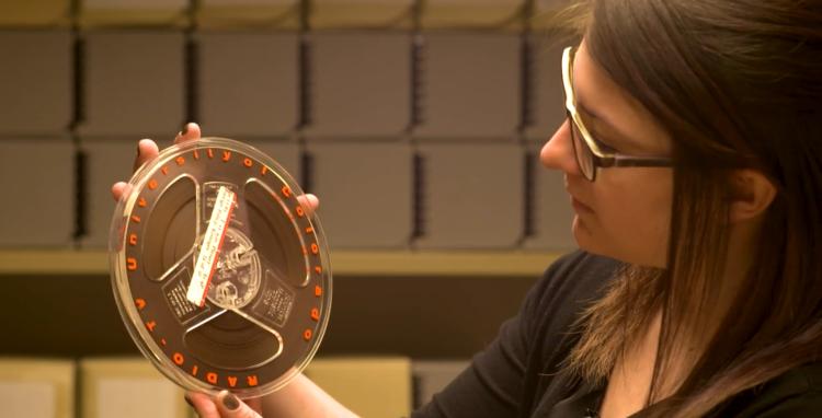 CU Boulder archivist Jane Thaler looks at a tape of a 1961 plenary talk by Henry Kissinger.