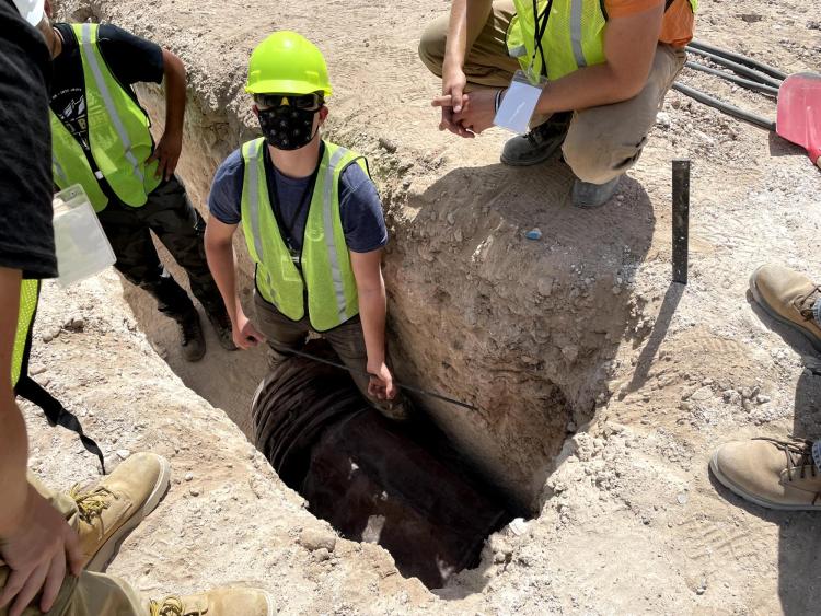 CU Hyperloop team members stand in a hole during the competition