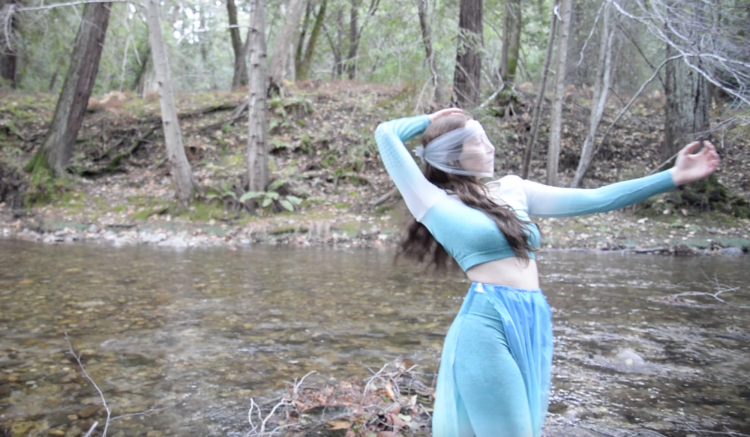 Rae Lewark performing near creek