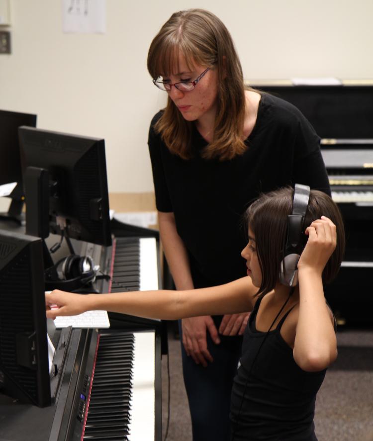 CU student teacher helps elementary student during Piano for Dreamers class