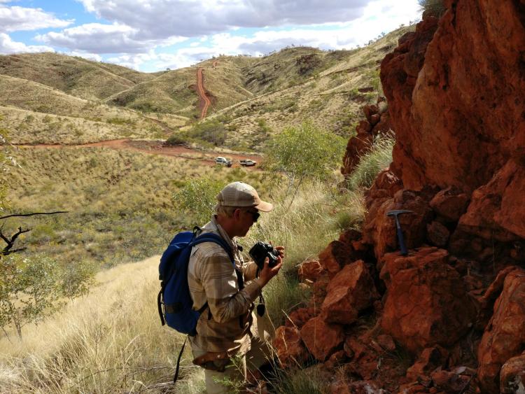 Benjamin Johnson inspects a rock outcrop near the site of an ancient hydrothermal vent in the Panorama district.