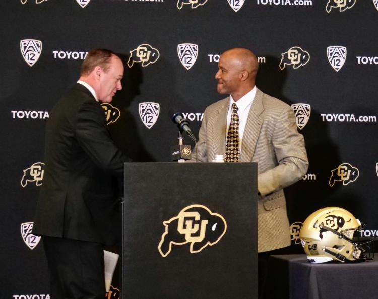 New CU football head coach Karl Dorrell, right, shakes hands with Athletic Director Rick George introduces him at a press conference at the Dal Ward Center at Folsom Field. (Photo by Glenn Asakawa/University of Colorado)