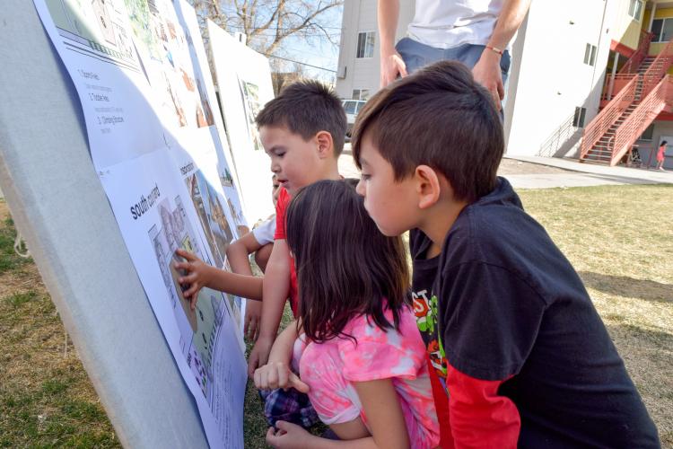 Children examine plans for the playground in their Denver neighborhood