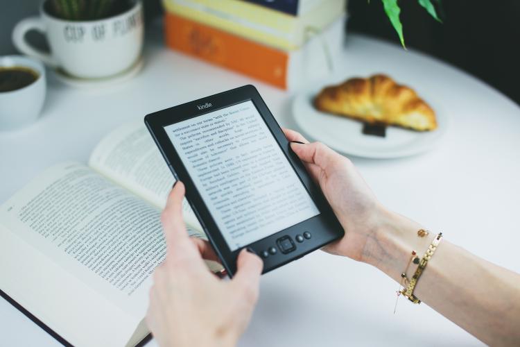 Woman reads book on Kindle e-reader