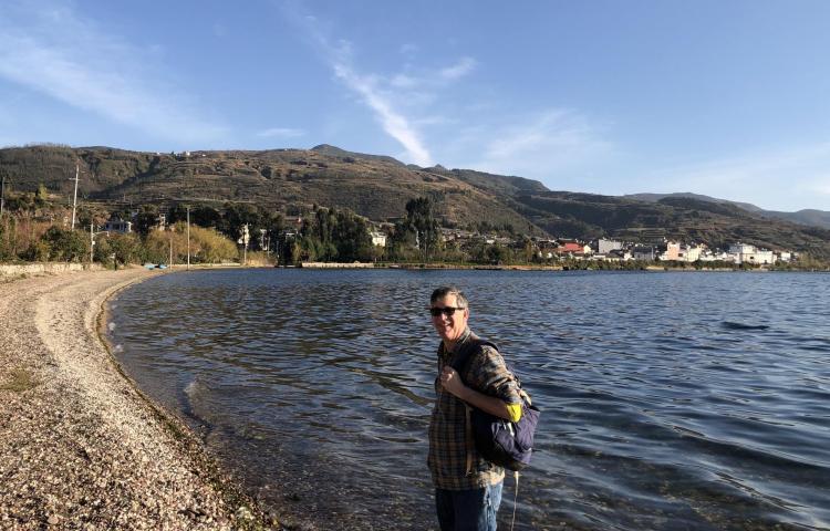 Patrick Kociolek standing on the shore of a lake