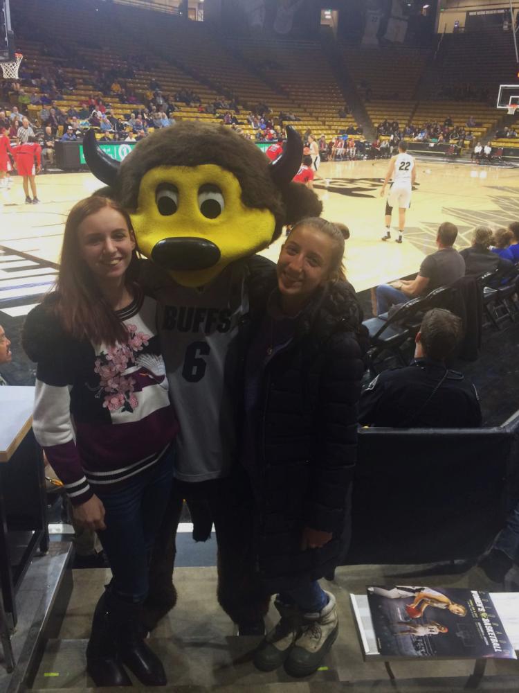 Bara, right, and a friend pose for a photo with Chip at a Buffs basketball game
