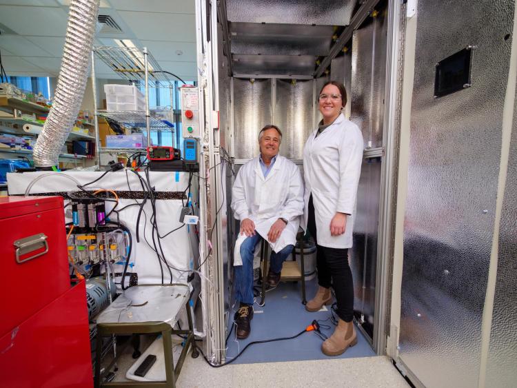 Professor Mark Hernandez and doctoral graduate Marina Nieto-Caballero standing inside the bioaerosol chamber on campus