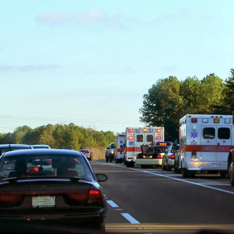 Cars drive past emergency vehicles pulled over in right lane