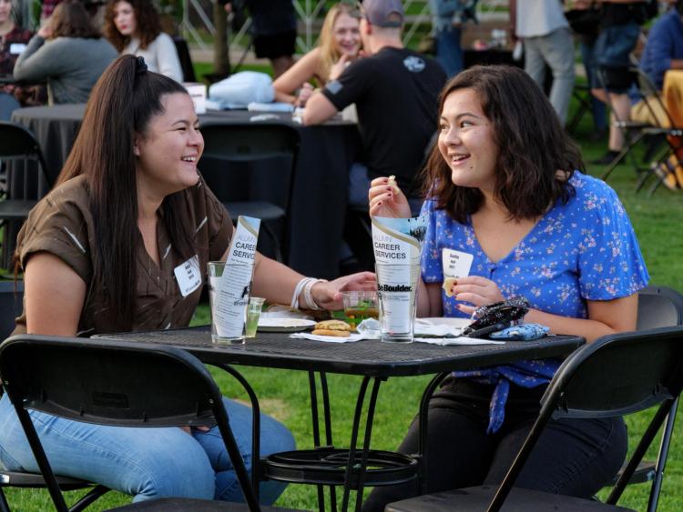 two students talking at an outdoor event