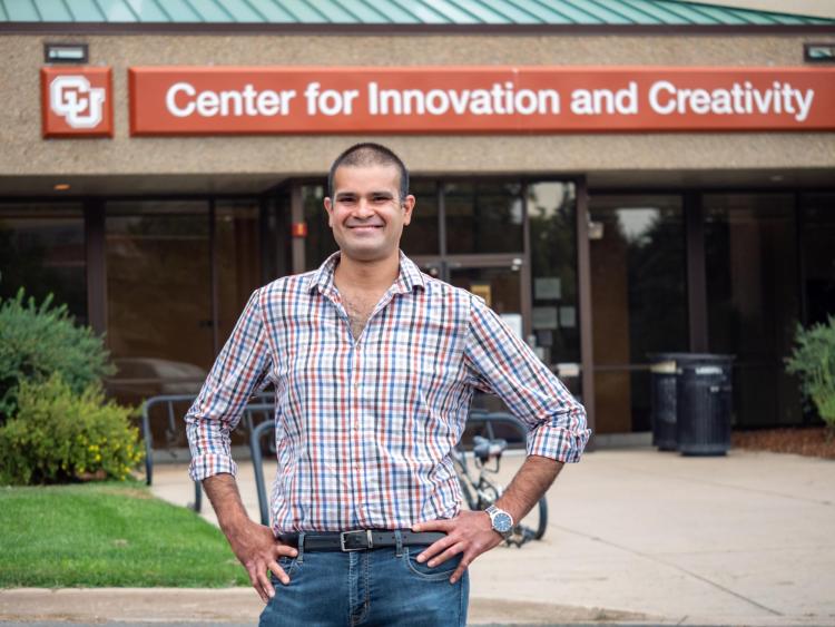 Sidney D'Mello stands in front of a building with a sign reading: "Center for Innovation and Creativity."
