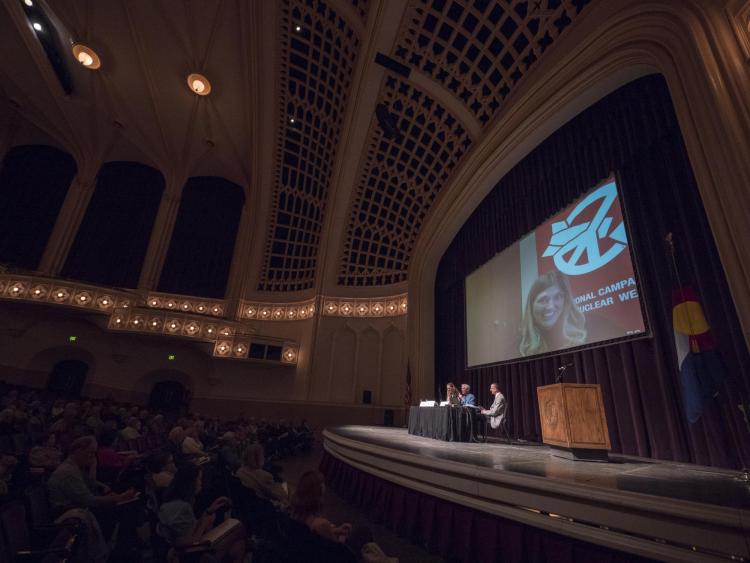 Susi Snyder, Joe Cirincione and Beatrice Fihn, on screen, discuss nuke disarmament. Bryan Taylor moderates. Photo by Glenn Asakawa.