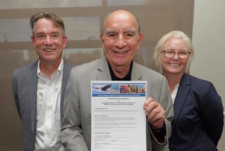 Patrick O’Rourke, Chancellor Phil DiStefano and Jessica Doty pose with the signed Okanagan Charter