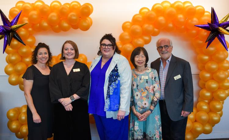 CU Ombuds Office staff pose in front of orange balloons in the shape of the number 50