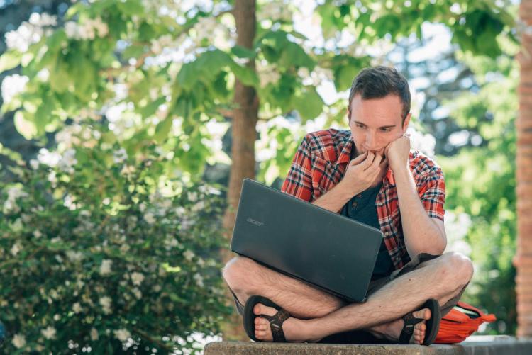Student working on laptop outside
