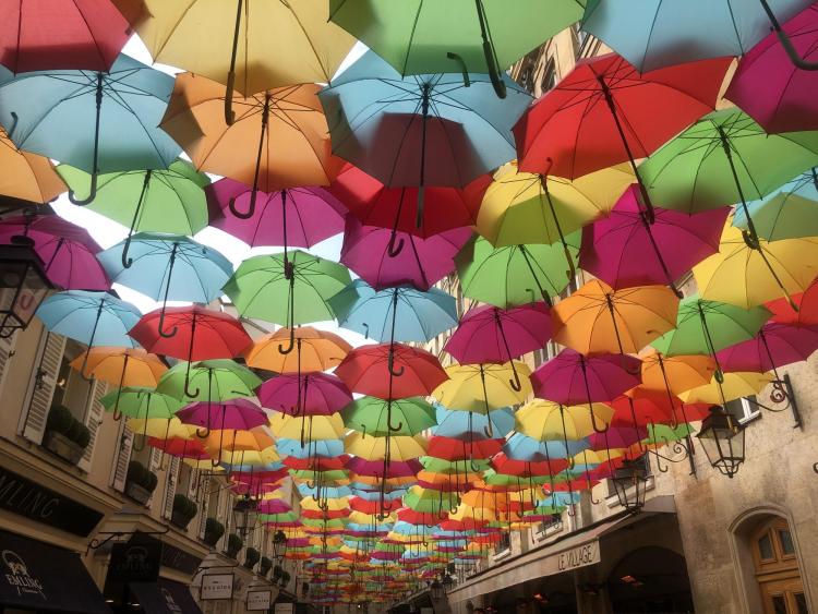 Colorful umbrellas cover a Paris street