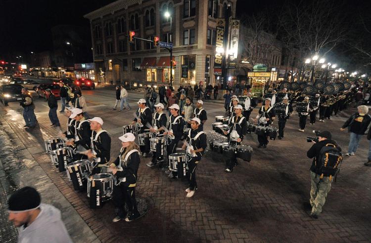 The CU marching band parades down Pearl Street