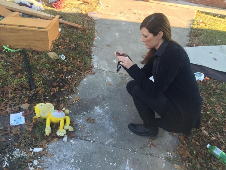 Lori Peek takes a photo of a stuffed animal on the ground