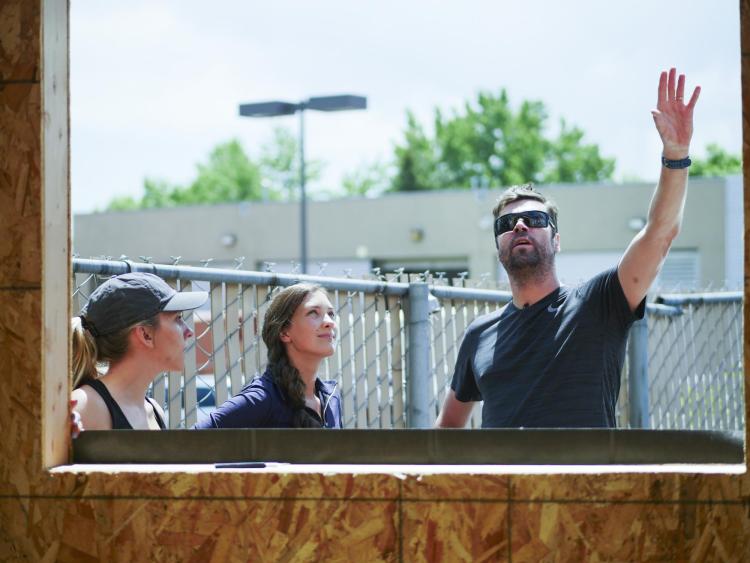 Students stand outside a pocket studio and talk.