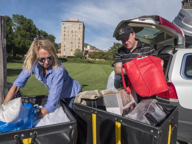 Jared Polis helps Kirsten Lemma of Broomfield unload her car full of belongings for her daughter Katherine