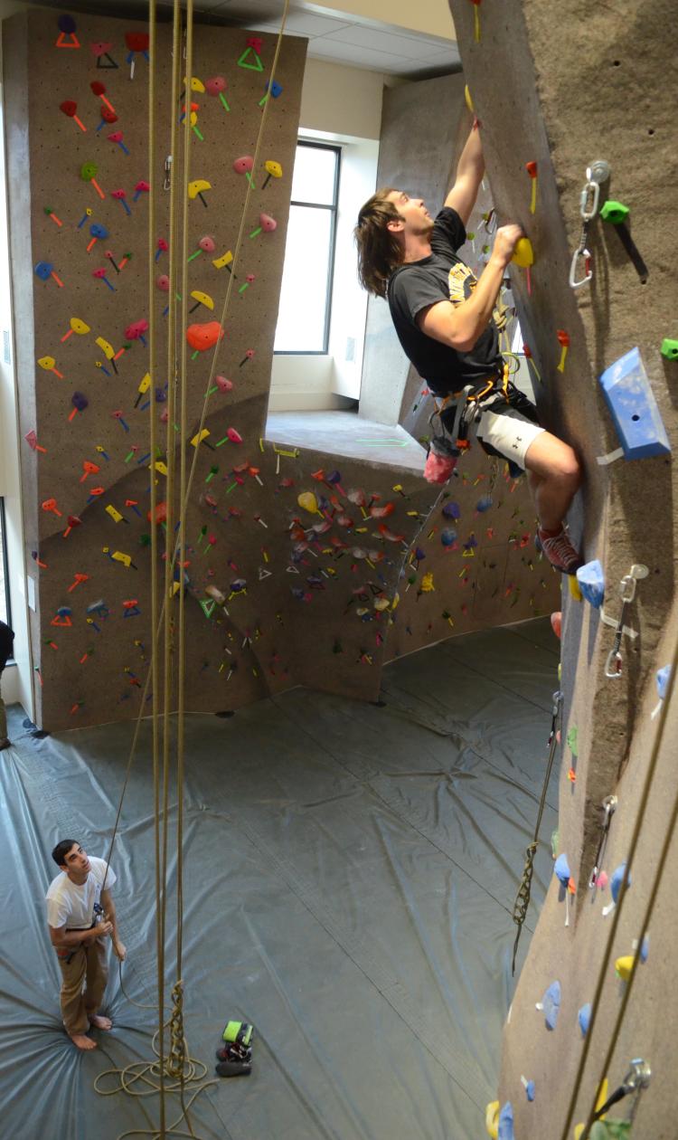 A student scales the CU Boulder climbing wall