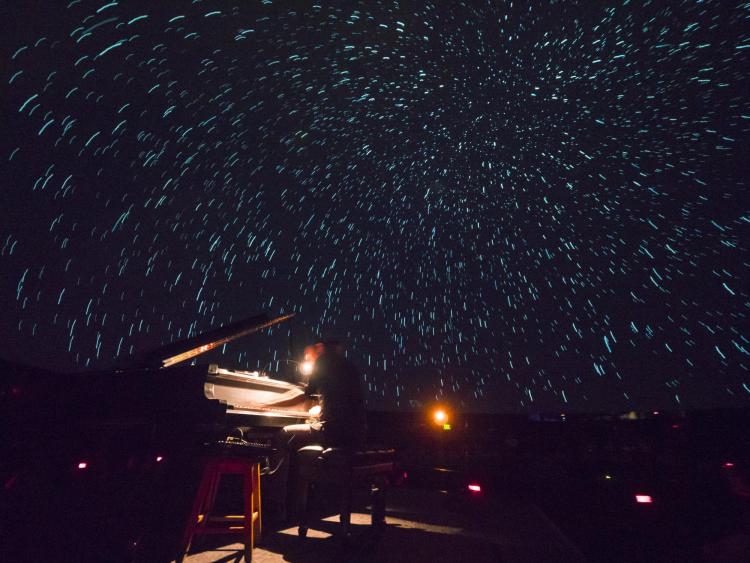 Roman Zavada performs live to lasers and footage of the Aurora Borealis in Northern Canada at Fiske Planetarium. Photo by Glenn Asakawa.