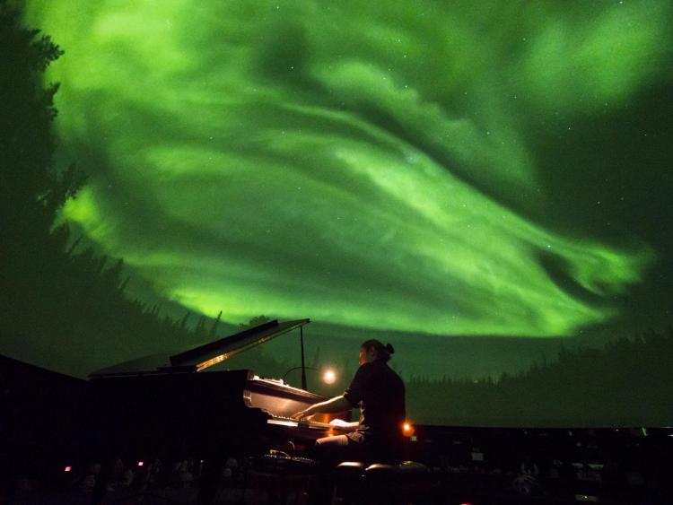 Roman Zavada performs live to lasers and footage of the Aurora Borealis in Northern Canada at Fiske Planetarium. Photo by Glenn Asakawa.