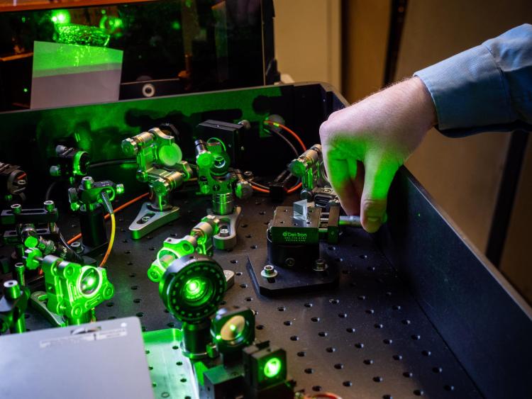 CU Boulder physicist Robert Karl tuning lasers in the lab