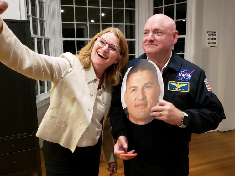 Kristen Browning-Blas takes a selfie with Scott Kelly while holding a cutout of NASA astronaut Kjell Lindgren