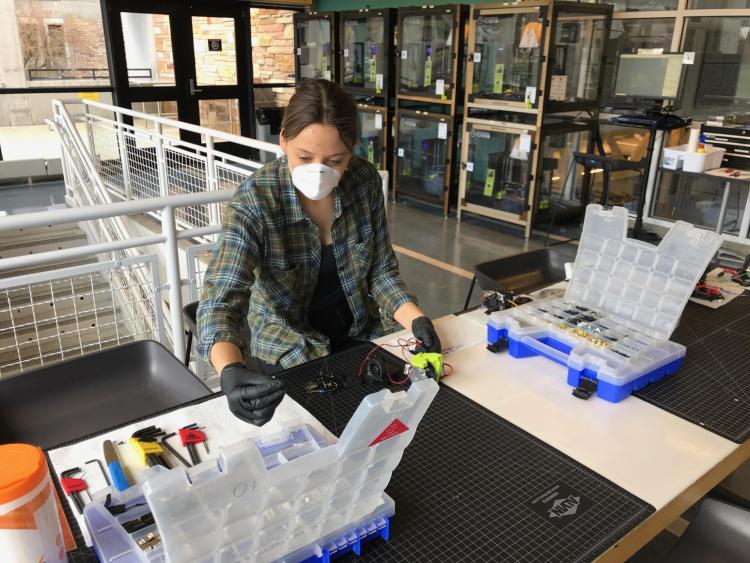 Rachel Sharpe conducts repairs on one of the 3D printers.