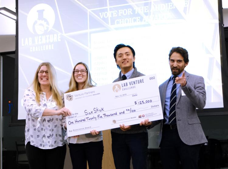 The SickStick team poses with a check for $125,000 after a big win in a competition called the Lab Venture Challenge.
