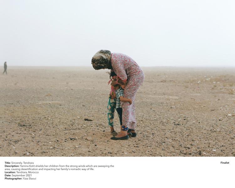 Yamina Kotit shields her children from the strong winds that are sweeping the area in Morocco.
