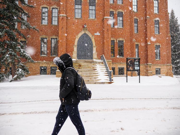 Student walks on snowy campus