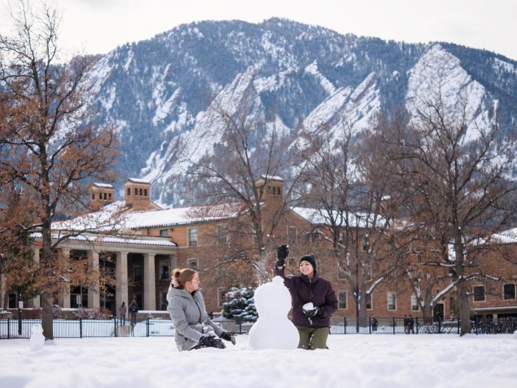 Students build a snowman on campus