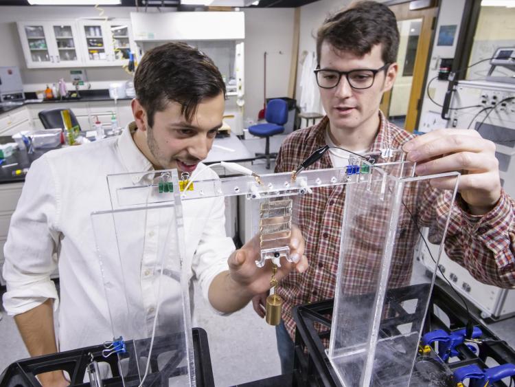 Nick Kellaris, a materials science and engineering graduate student, left, and Mechanical engineering graduate student Eric Acome, looks over liquified artifical "muscle" or soft robot material in the Keplinger Research Lab.
