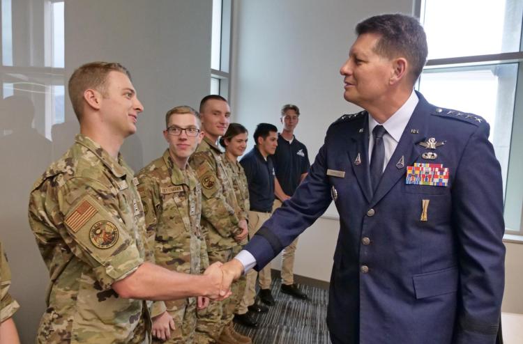 Gen. Thompson shakes hand with an ROTC cadet in fatigues