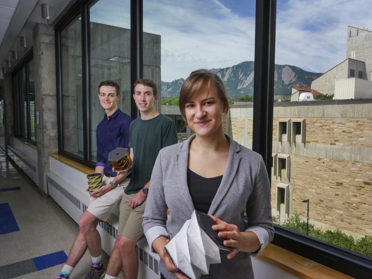 Andrew Pfefer, Anastasia Muszynski and Dawson Beatty pose with their origami devices